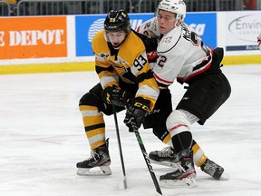 Norfolk County's Maddox Callens, of the Kingston Frontenacs, tries to get away from Owen Sound Attack Adam McMaste during an Ontario Hockey League game in January.