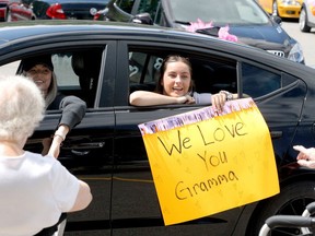 Kathleen Ford, right, expresses best wishes to her grandmother while Logan Ford drives by during a belated Mother's Day parade for residents at Royal Brock Retirement Living on Saturday morning. (RONALD ZAJAC/The Recorder and Times)