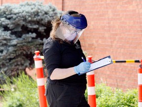 Linda Nastuk, a bylaw officer with the city of Brockville, wears personal protective equipment as she does intake at the COVID-19 testing centre at the Brockville Memorial Centre on Thursday afternoon. (RONALD ZAJAC/The Recorder and Times)