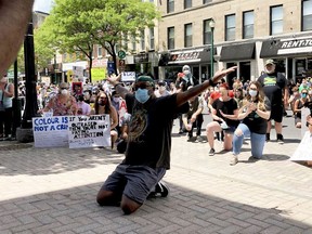 Anti-racism protesters take a knee in front of Brockville city hall Saturday as Tom Alston demonstrates how African-Americans are expected to exit a vehicle safely during a police stop. Hundreds of people marched form the Court House Green to city hall in solidarity with anti-racism protests around the world following the death of George Floyd at the hands pf police in Minneapolis. (RONALD ZAJAC/The Recorder and Times)