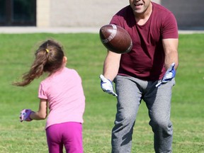 Bob Artelle plays catch with his six-year-old daughter, Kaleesy, at Ursuline College Chatham on Monday. Mark Malone/Postmedia Network