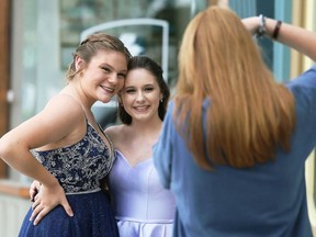 Jocelyn Dowdall, left, and Grace Castillo pose for photographer Ella Dam in downtown Chatham on Friday. Dam offered her services to FreeHelpCK, which held a drive-up prom for Grade 12 students whose school prom was cancelled because of the COVID-19 pandemic. Forty students from at least six high schools signed up for the two-day event that began June 25. Each received a photo shoot and a gift bag. Dowdall is in Grade 12 at Chatham-Kent and Castillo is in Grade 9 at Ursuline. (Mark Malone/Postmedia Network)
