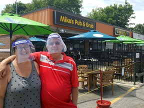 Donning protective equipment, Brenda Buckler, and her husband, Mike, co-owners of Mike's Place in Chatham, are shown outside the patio of their establishment. (Trevor Terfloth/The Daily News)