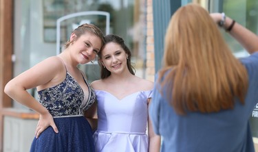 Jocelyn Dowdall, left, and Grace Castillo pose for photographer Ella Dam in downtown Chatham in Chatham, Ont., on Friday, June 26, 2020. They took part in FreeHelpCK's drive-up prom for Grade 12 students whose school prom was cancelled because of the COVID-19 pandemic. Graduates could invite one guest. Dowdall, who's graduating from Chatham-Kent Secondary School, invited Castillo, a Grade 9 student at Ursuline College Chatham. Mark Malone/Chatham Daily News/Postmedia Network