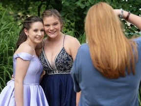 Grace Castillo, left, and Jocelyn Dowdall pose for photographer Ella Dam in downtown Chatham in Chatham, Ont., on Friday, June 26, 2020. They took part in FreeHelpCK's drive-up prom for Grade 12 students whose school prom was cancelled because of the COVID-19 pandemic. Graduates could invite one guest. Dowdall, who's graduating from Chatham-Kent Secondary School, invited Castillo, a Grade 9 student at Ursuline College Chatham. Mark Malone/Chatham Daily News/Postmedia Network