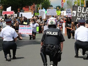 Cornwall Police Chief Danny Aikman (right) and Deputy Chief Shawna Spowart (left), among those kneeling as a sign of solidarity with supporters. Photo on Saturday, June 6, 2020, in Cornwall, Ont. Todd Hambleton/Cornwall Standard-Freeholder/Postmedia Network