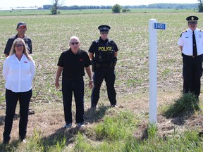 Farmer and South Dundas Coun. Archie Mellan (back) hosted a small gathering Wednesday morning for the first civic  address sign in the community as part of the Emily 911 Farm Entrance Program. From left are Jackie Kelly-Pemberton (regional director, Ontario Federation of Agriculture), Jim Shaw (director for Dundas Federation of Agriculture), OPP Const. Laura Dargie (Winchester detachment) and Cameron Morehouse (chief of South Dundas Fire & Emergency Services). Photo on Wednesday, June 17, 2020, in Hulbert, Ont. Todd Hambleton/Cornwall Standard-Freeholder/Postmedia Network