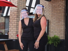 Chelsey Laperle and Sara VanRiel use personal protective equipment to serve customers at the patio outside of Shoeless Joes Sports Grill on Tuesday, June 23 2020,  in Cornwall, Ont. Joshua Santos/Cornwall Standard-Freeholder/Postmedia Network