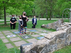 Owen Sound Police Chief Craig Ambrose, left, and Owen Sound Mayor Ian Boddy take a knee at the black history cairn at Owen Sound's Harrison Park Wednesday in response to the death of George Floyd. They were joined at the cairn by Rebecca Ironmonger, who's holding her dog Opal, and Ironmonger's daughter Scarlett Haight. DENIS LANGLOIS