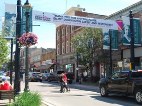 Shoppers walk under one of the new cross-street banners on 2nd Avenue East that thank people for "hitting pause" during the COVID-19 pandemic and welcome people back to Owen Sound's downtown. DENIS LANGLOIS