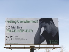 A SOS Crisis Line sign concerning mental health is seen on Highway 63 at the south end of Fort McMurray on Thursday, April 6, 2017. Ian Kucerak/Postmedia