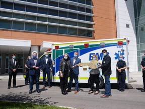 Officials with the Alberta government and EMS take part in a ceremony involving Alberta Infrastructure symbolically handing over the key for the Grande Prairie Regional Hospital to Alberta Health Services in front of the facility in Grande Prairie, Alta. on Friday, June 26, 2020. The hospital is expected to start accepting patients by mid-2021 once the commissioning is completed.
