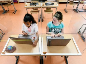 Pupils sitting behind partition boards made of Plexiglass attend a class at a primary school, during the coronavirus disease (COVID-19) outbreak, in Den Bosch, Netherlands, May 8. REUTERS/Piroschka van de Wouw