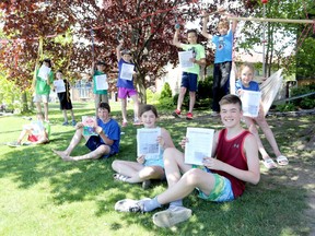 Children from Kingston's Calvin Park neighbourhood show off their hard-copy community newsletter, a project that started in the days following school closures. The group is working on the fourth edition of Celebrating Simple Times. (Meghan Balogh/The Whig-Standard)