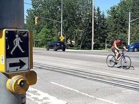 Vehicle and cycling traffic moves through the corner of Gore Road and Highway 15 on Monday. (Ian MacAlpine/The Whig-Standard)