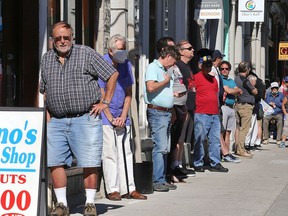 More than 25 people waited over 90 minutes outside of Dino's Barbershop on Princess Street on Friday morning to get a haircut. (Ian MacAlpine/The Whig-Standard