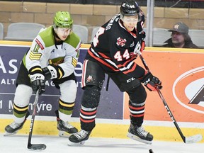 Liam Arnsby of the North Bay Battalion competes with the Niagara IceDogs' Akil Thomas for a loose puck in the teams' Ontario Hockey League game last November. 
Sean Ryan file photo