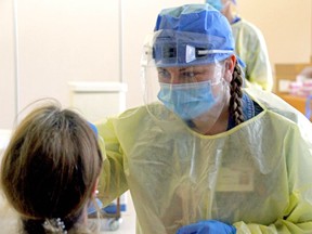 A worker in Ontario performs a COVID-19 test on a citizen in June. While a number of sites to be checked for the disease exist in Canada and Alberta, there is no local space in Spruce Grove and Stony Plain, to the frustration of many residents.