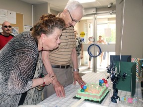 Colleen Walsh helps Albert Lemire blow out the candles on his birthday cake, Friday. Lemire turned 97, and his neighbours got together to help him celebrate the milestone.PJ Wilson/The Nugget
