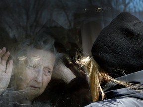 Diane Colangelo visits her 86-year-old mother Patricia through a window at the Orchard Villa long-term care home in Pickering on April 22.