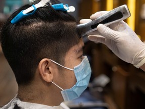 A man wearing a protective face mask gets his hair cut, as barbershops and salons are allowed to reopen after over two months of lockdown amid the coronavirus disease (COVID-19) outbreak, in Mandaluyong City, Metro Manila, Philippines, June 8, 2020. 
REUTERS/Eloisa Lopez