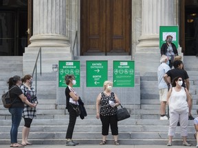 People wear face masks as they wait to enter the Museum of Fine Arts in Montreal, Saturday, June 6, 2020, as the COVID-19 pandemic continues in Canada and around the world. A new poll suggests Canadians are increasingly wearing protective face masks as they emerge from months of isolating at home to curb the spread of COVID-19.THE CANADIAN PRESS/Graham Hughes