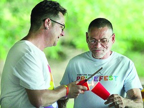 Celebration of Life organizer David Cartner (right) and Jeremy Nadon light a candle Sunday, July 28, 2019 evening at Bellevue Park gazebo in Sault Ste. Marie, Ont. The sixth annual Sault Ste. Marie Pridefest's closing event was held to remember, honour and celebrate, those lost to HIV/AIDS and salute those affected by, or currently live with, the virus. POSTMEDIA NETWORK