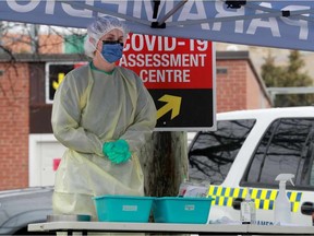 FILE — Nurses take COVID-19 swabs at drive-thru testing site. Postmedia