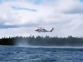 A coast guard helicopter assists in the rescue of two kayakers who capsized in Lake Huron near Providence Bay.