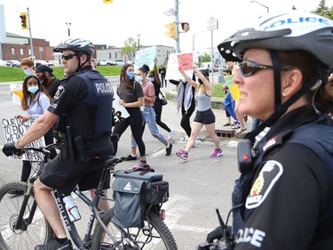 Protesters pass by police officers during a protest against racism and police brutality in Sudbury, Ont. on Wednesday June 3, 2020. A demonstration was held at Memorial Park, followed by a march to the Bridge of Nations. John Lappa/Sudbury Star/Postmedia Network