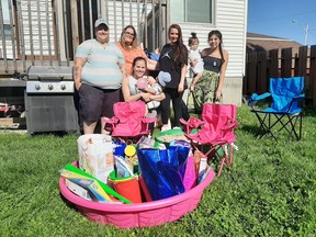 From left to right: Alyssa Szwed, Tiffany Lundrigam, Jeseanne Lacasse, and Alexis Pelland pose with her three children Destiny, Justice, and Ryley in front of a kiddie pool filled with gifts put together by Greater Sudbury's 'Wine Ninjas.'