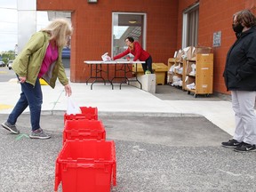 Anne Schijns, left, drops items off at the Greater Sudbury Public Library in New Sudbury on Thursday June 11, 2020.