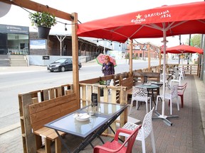 A pedestrian walks by La Fromagerie patio that opened in Sudbury, Ont. on Friday June 12, 2020.