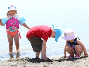 Adalayia Murray, 3, left, plays at the main beach at Bell Park in Sudbury, Ont. with her brother, Parker, 5, and Stella Lingenfelter, 2 earlier this week. Sudbury is under a heat warning Saturday and Sunday.