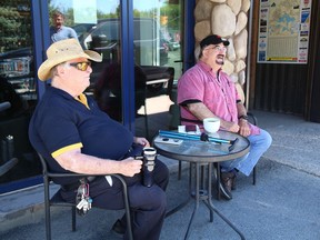 Gary Brown, left, and Peter Hudyman share a laugh while sipping on a cup of coffee at the Old Rock Coffee Roastery patio on Minto Street on Tuesday.