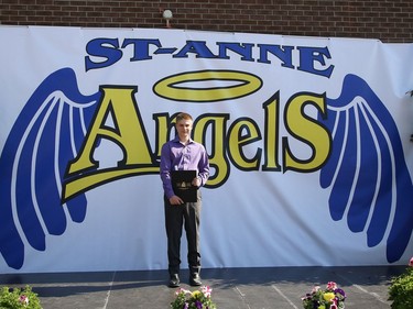 Eric Belanger, 14, poses for a picture with his graduation certificate at St. Anne Catholic School's Grade 8 drive-thru graduation ceremony in Hanmer, Ont. on Wednesday June 17, 2020. More than 50 graduating students and their families took part in the ceremony. John Lappa/Sudbury Star/Postmedia Network