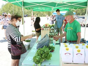 Mary Ali purchases fresh produce from Stuart McCall, of McGrow's Farms and Gardens, at The Sudbury Market located at the York Street parking lot in Sudbury, Ont. on Thursday June 18, 2020. The market is being held on York Street on Thursdays from 2 p.m. to 7 p.m., and the Saturday market will temporarily be held at the York Street site from 8 a.m. to 2 p.m.