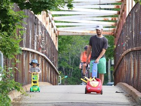 Don MacNeil and his son, Samuel, 2, walk on the Nelson Street pedestrian bridge while going for a stroll in Sudbury, Ont. on Monday June 22, 2020.