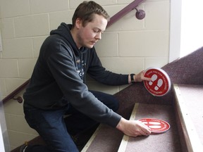 Pastor Jon Mann for youth and connections at the First Baptist Church in Timmins places signs on the steps of the church auditorium to remind attendees of physical distancing requirements as churches in Ontario have been given permission to re-open. The First Baptist Church will welcome back its parishioners for its first Sunday service in months on June 21. 

RICHA BHOSALE/The Daily Press