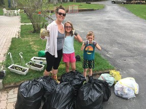 Amy, Eve and Russel Southward stand beside the mound of garbage that they collected as part of the clean up challenge at Cochrane Public School..TP.jpg
