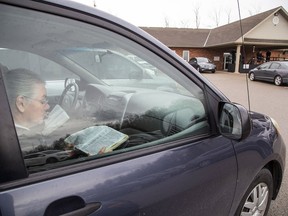 A parishioner reads from a bible during a drive-in church service in Ontario earlier in the year. The Engage Church in Spruce Grove will be hosting its first drive-in service and film Sunday at the TransAlta Tri-Leisure Centre.