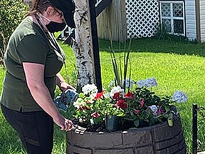 Millet and District Museum staff Brittney Trimming planting the planters in front of fire wagon.
Millet and District Museum