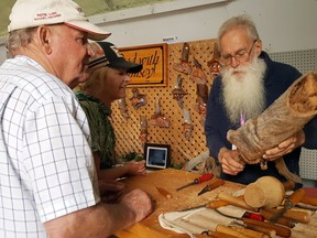 Brock Blosser of Wood with Whimsey in Sioux Narrows explains the steps he takes to begin a carving at the 57th annual Sioux Narrows Arts Festival in 2018.