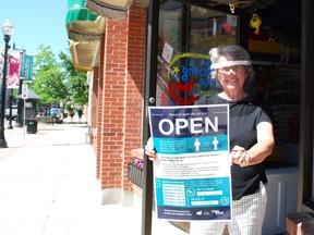 The Rocking Horse is among the downtown Owen Sound businesses that have their doors open again after being temporarily closed due to the COVID-19 pandemic. Here, the toy store's co-owner Deb Haswell holds up one of the window signs that includes pandemic-related physical distancing and other safety guidelines. DENIS LANGLOIS