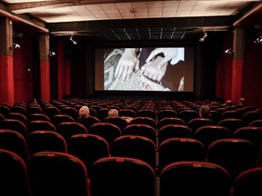 People sit in a cinema Monday, June 15, 2020. A new poll suggests two-thirds of Canadians don't want to relax the physical distancing rules imposed to curb the spread of COVID-19. And if they were relaxed, fewer than half would feel comfortable taking part in activities that would bring them closer to other people, like going to a movie theatre.