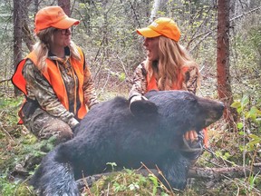 Amanda Lynn Mayhew, right, poses the 350 pound black bear she harvested while shooting an episode of her outdoors TV series THAT Hunting Girl earlier this month while in the Timmins. She was hunting along with an old school chum of hers, Jewels Roy, of Smooth Rock Falls.

Supplied