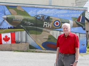 Robert Smith, a 40-plus-year Royal Canadian Legion member, in front of the most recent part of the mural he commissioned, by artist Shane Gaudreault, on the west side of the Capt. Matthew J. Dawe Memorial Legion Branch 631 in Kingston on Wednesday. (Julia McKay/The Whig-Standard)