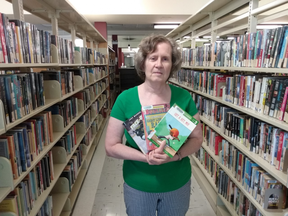 Ellen Dark, a community librarian in Sarnia, holds a selection of books. The Lambton County Library has launched this year's summer reading program online while its branches are closed due to COVID-19 restrictions.