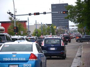 Dozens of vehicles make their way through the downtown core to witness a reverse parade in honour of Canada Day in Grande Prairie, Alta. on Saturday, July 4, 2020. The parade had been postponed from July 1 to July 4 due to forecasted extreme weather conditions.