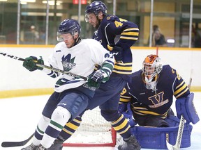 Brett Jeffries of the Nipissing Lakers battles for the puck with Laurentian Voyageurs Nicolas Thommen as Voyageurs goalie Gunner Rivers looks on during OUA men's hockey exhibition action in Sudbury. Nipissing won an eight-player shootout but then lost in a rematch at Memorial Gardens, Saturday, by a 3-1 score.